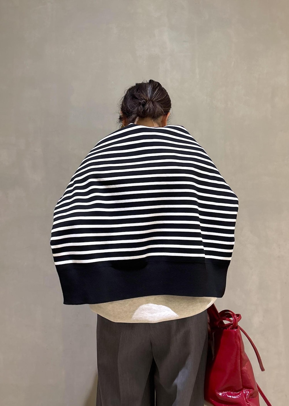 グレー系のスラックス、ホワイト系のスウェット、ブラック系のニット/セーターを着用したレディースの冬コーディネートの10枚目の写真