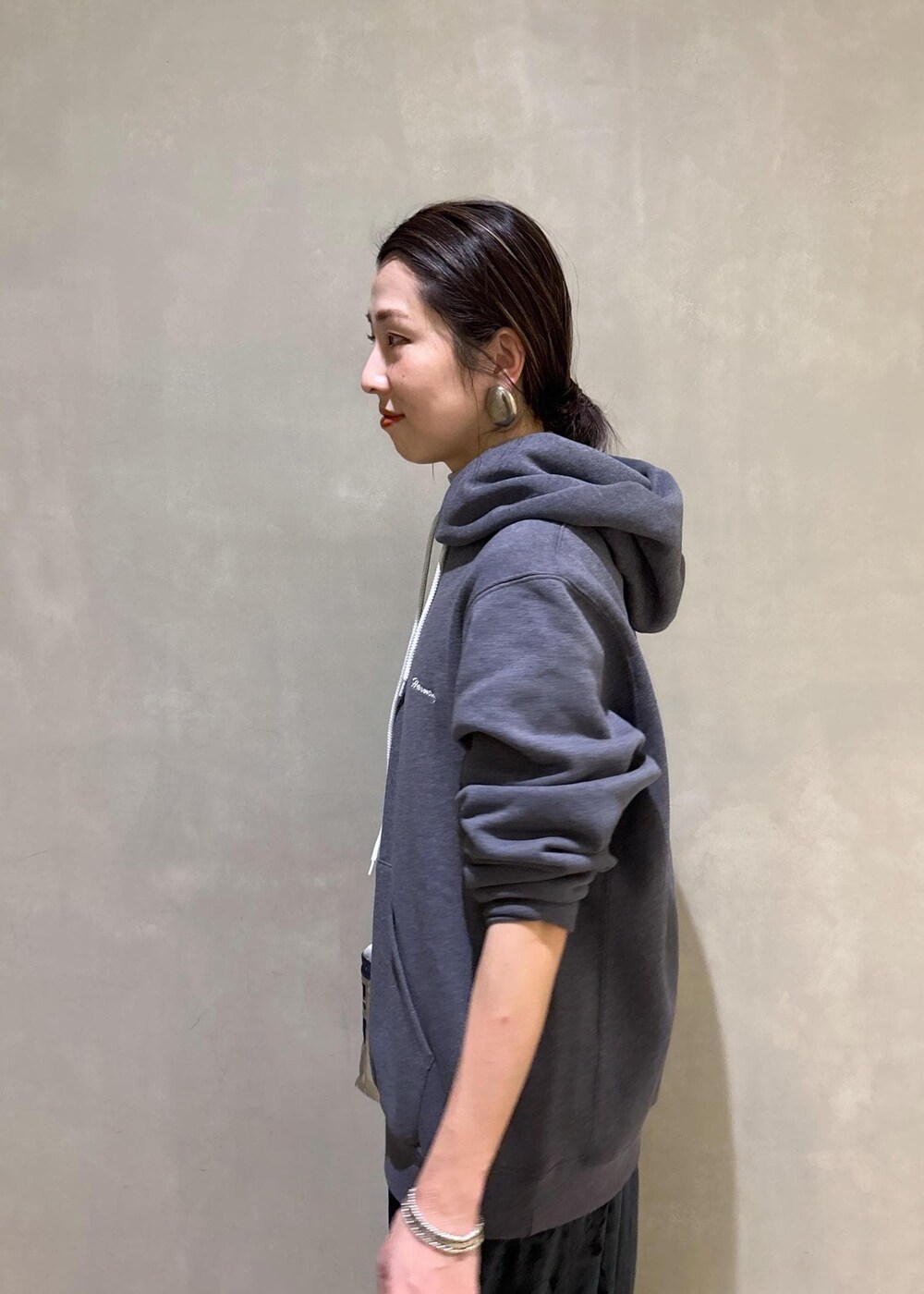 グレー系のスニーカー、ブラック系のスカート、グレー系のパーカーを着用したレディースの冬コーディネートの9枚目の写真