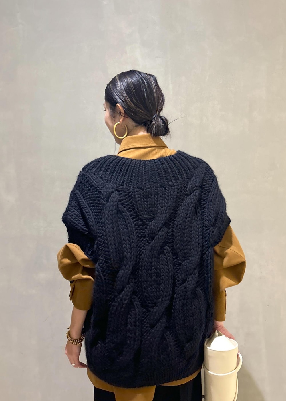 ブラック系のニット/セーター、ゴールド系のブーツ、イエロー系のブルゾンを着用したレディースの秋コーディネートの10枚目の写真