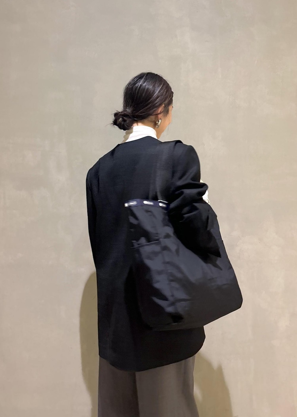 グレー系のスニーカー、ホワイト系のニット/セーター、ブラック系のシャツ/ブラウスを着用したレディースの秋コーディネートの9枚目の写真