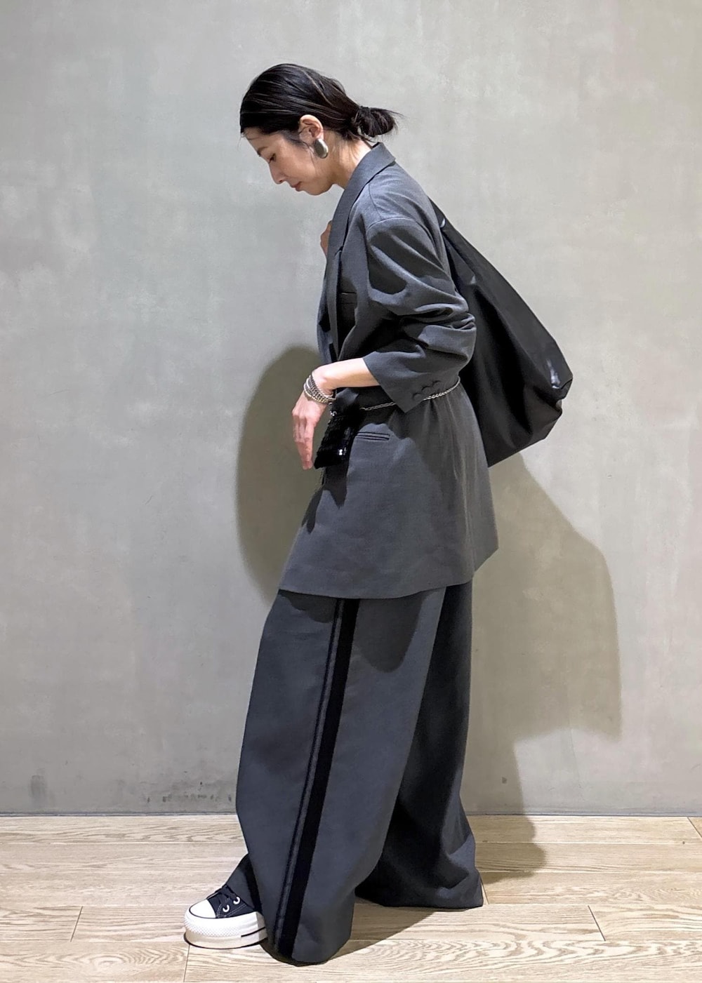 ブラック系のショルダーバッグ、グレー系のその他パンツ、グレー系のテーラードジャケットを着用したレディースの冬コーディネートの5枚目の写真