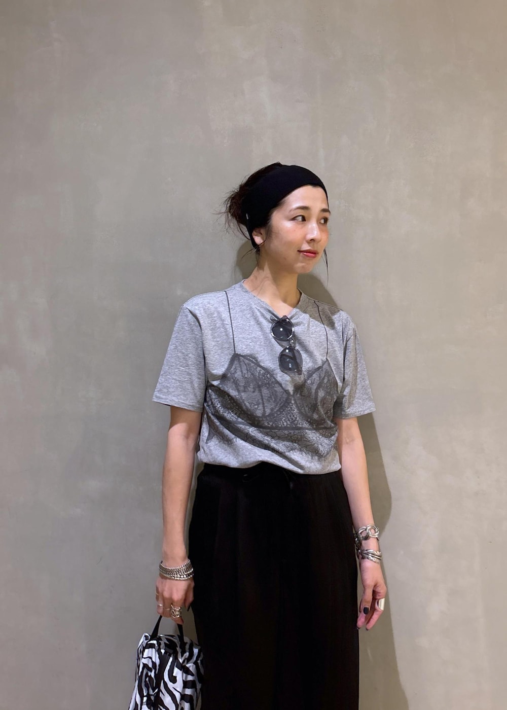 グレー系のTシャツ/カットソー、ブラック系のスラックス、ホワイト系のネックレスを着用したレディースの夏コーディネートの8枚目の写真