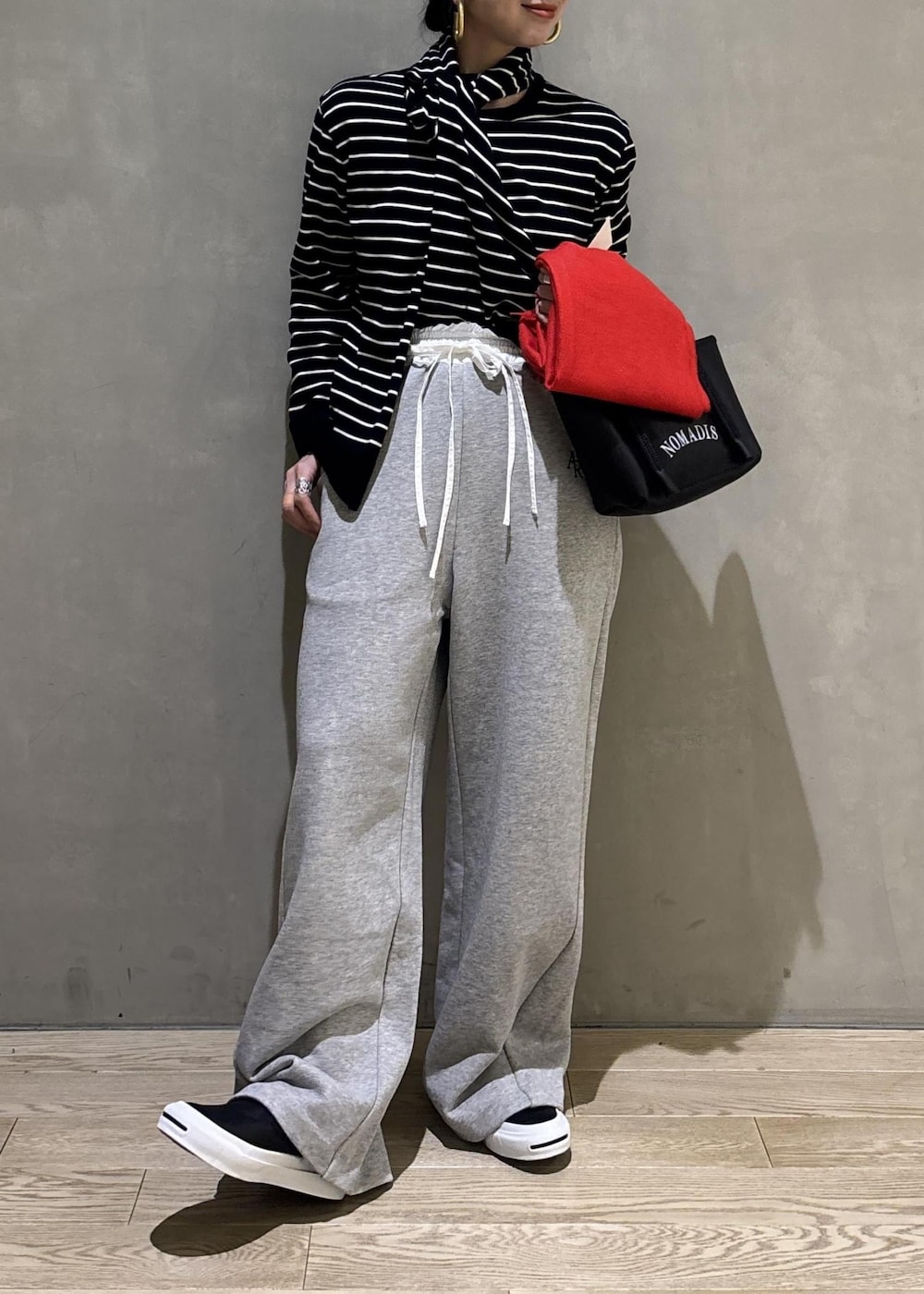 グレー系のその他パンツ、レッド系のマフラーを着用したレディースの冬コーディネートの6枚目の写真