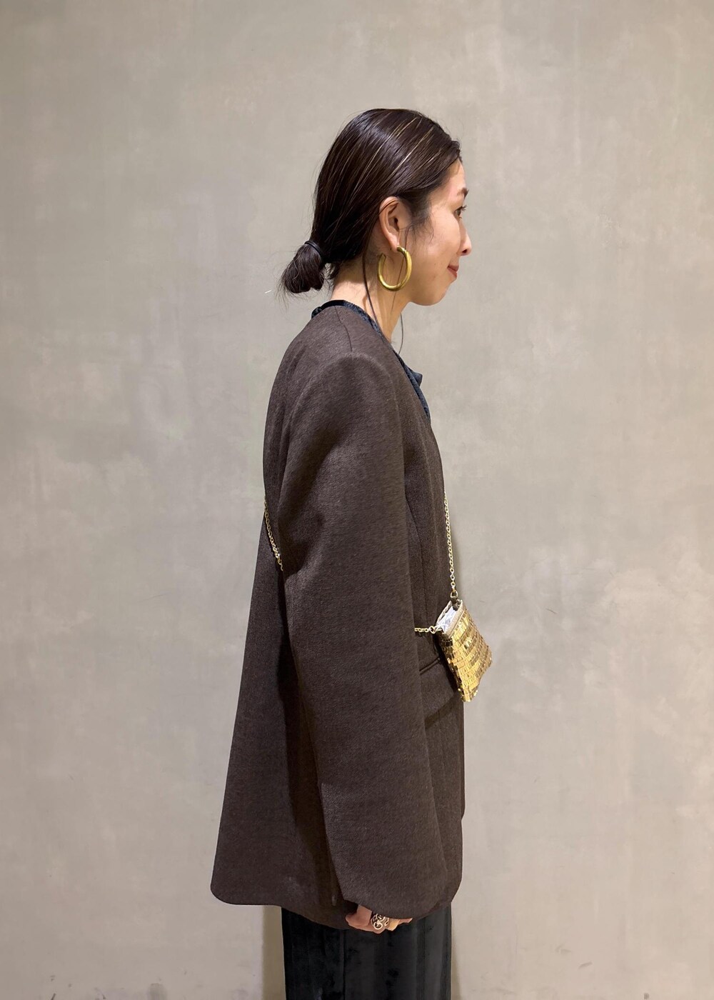 ブラック系のスカート、ブラック系のTシャツ/カットソー、ゴールド系のブーツを着用したレディースの冬コーディネートの10枚目の写真