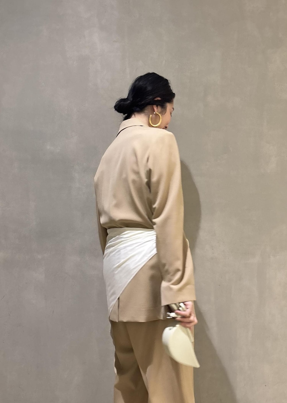 ベージュ系のテーラードジャケット、ホワイト系のシャツ/ブラウス、ベージュ系のスラックスを着用したレディースの冬コーディネートの9枚目の写真