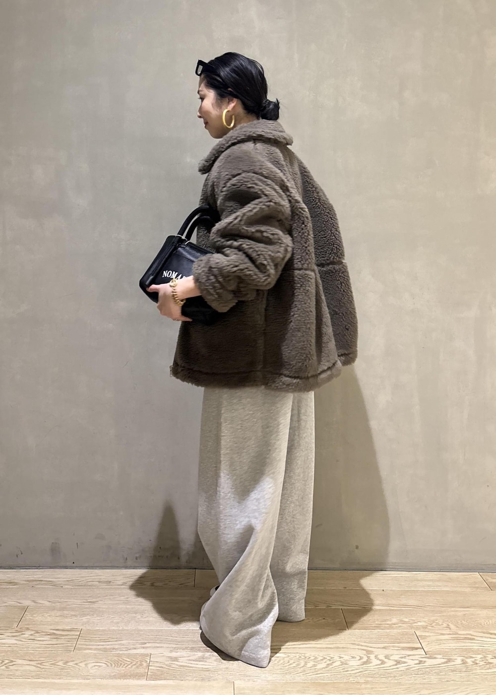 グリーン系のブルゾン、グレー系のその他パンツを着用したレディースの冬コーディネートの6枚目の写真