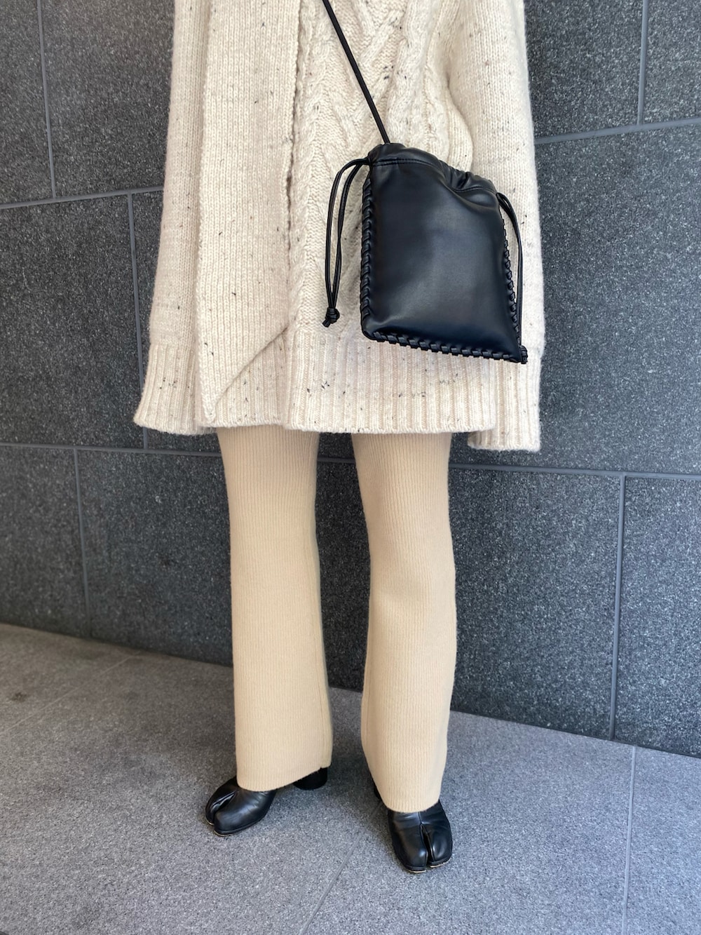 ブラック系のブーツ、ベージュ系のその他パンツ、ブラック系のショルダーバッグを着用したレディースの春コーディネートの3枚目の写真