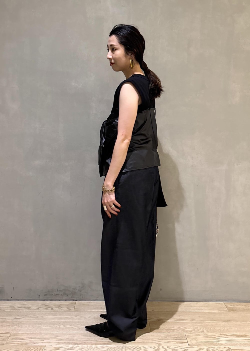 ブラック系のサンダル、ブラック系のデニムパンツ、ベージュ系のショルダーバッグを着用したレディースの夏コーディネートの6枚目の写真