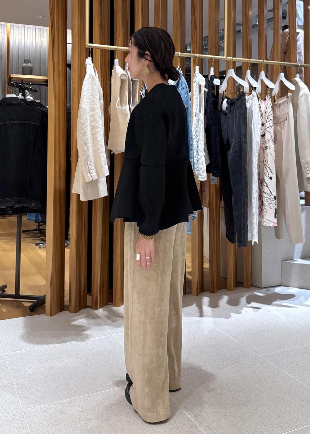 ベージュ系のハンドバッグ、ブラック系のローファー、ブラック系のカーディガン/ボレロを着用したレディースの冬コーディネートの3枚目の写真