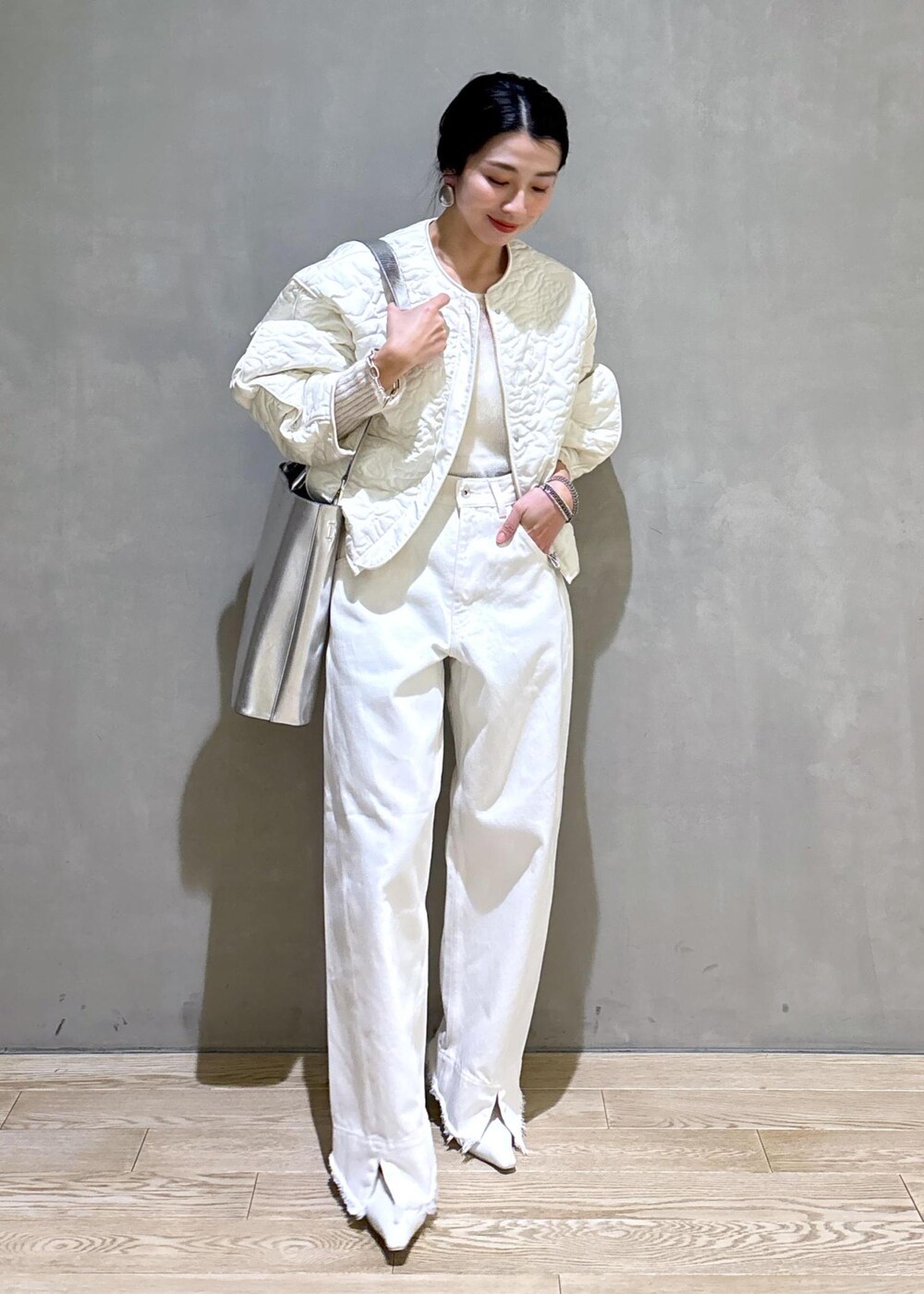 ホワイト系のパンプス、シルバー系のトートバッグ、ホワイト系のデニムパンツを着用したレディースの冬コーディネートの7枚目の写真