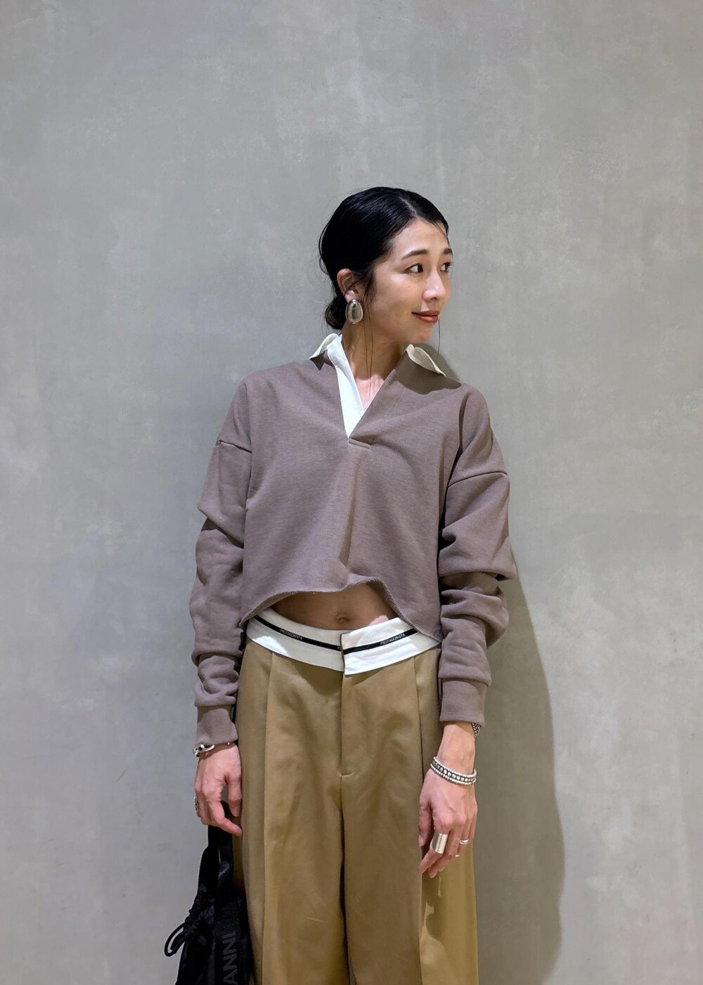 ブラック系のハンドバッグ、ブラウン系のサンダル、ベージュ系のTシャツ/カットソーを着用したレディースの秋コーディネートの5枚目の写真