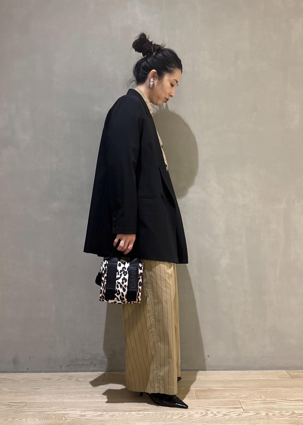 ベージュ系のショルダーバッグ、ベージュ系のスラックス、ベージュ系のシャツ/ブラウスを着用したレディースの秋コーディネートの5枚目の写真