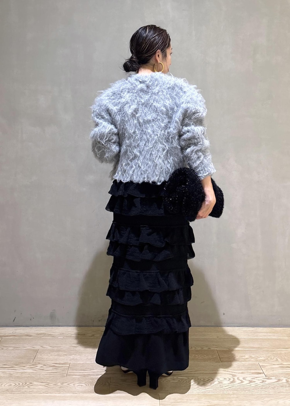 ブラック系のスカート、グレー系のカーディガン/ボレロ、ブラック系のトートバッグを着用したレディースの冬コーディネートの5枚目の写真