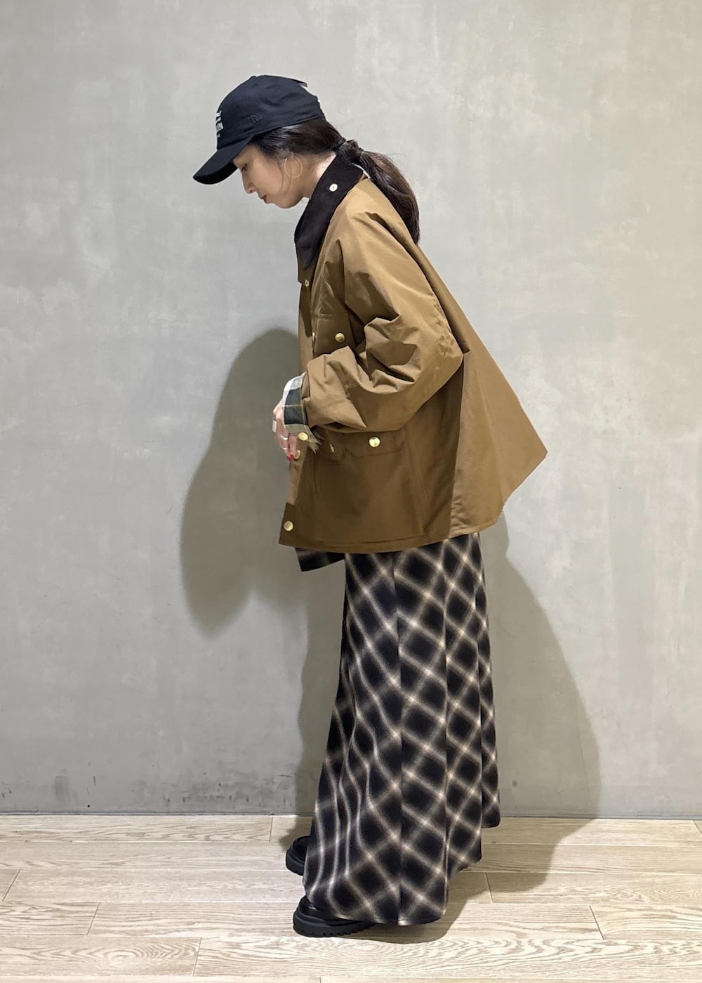 イエロー系のブルゾン、ブラック系のキャップを着用したレディースの秋コーディネートの3枚目の写真