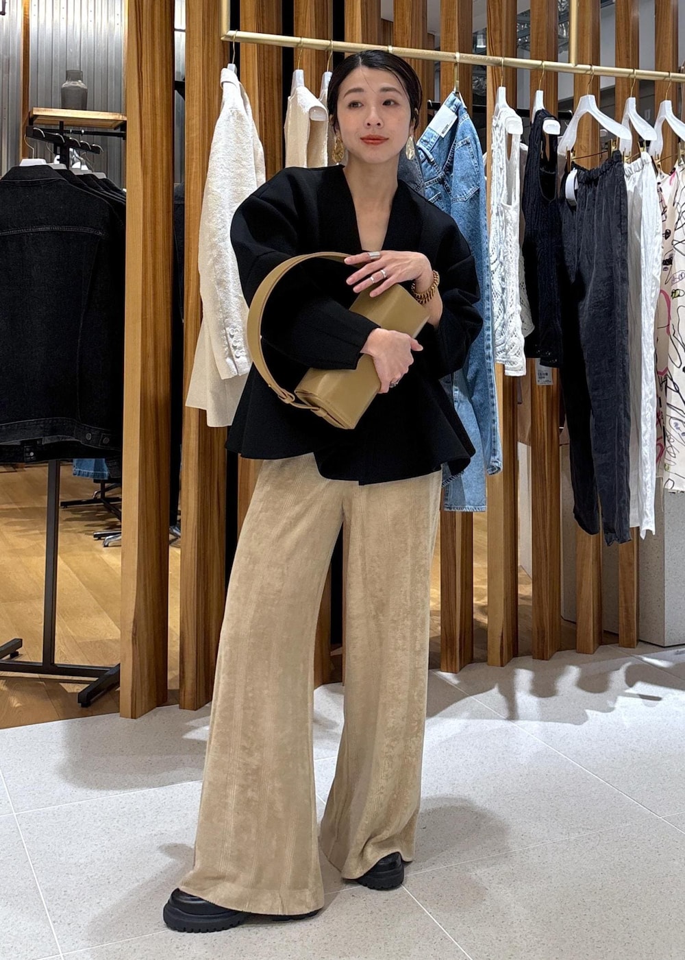 ベージュ系のハンドバッグ、ブラック系のローファー、ブラック系のカーディガン/ボレロを着用したレディースの冬コーディネートの6枚目の写真