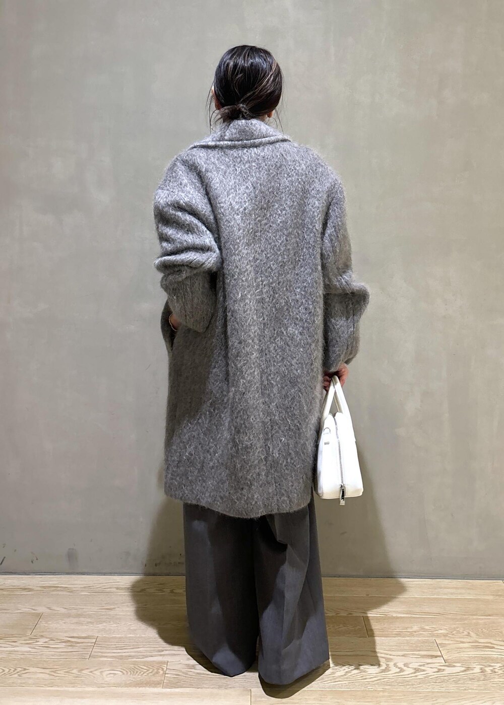 ホワイト系のボストンバッグ、グレー系のカーディガン/ボレロ、グレー系のチェスターコートを着用したレディースの秋コーディネートの5枚目の写真