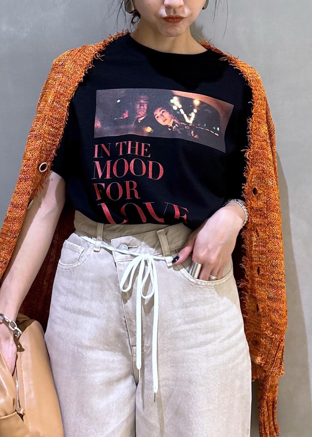 ベージュ系のハンドバッグ、ホワイト系のデニムパンツ、ホワイト系のTシャツ/カットソーを着用したレディースの春コーディネートの10枚目の写真