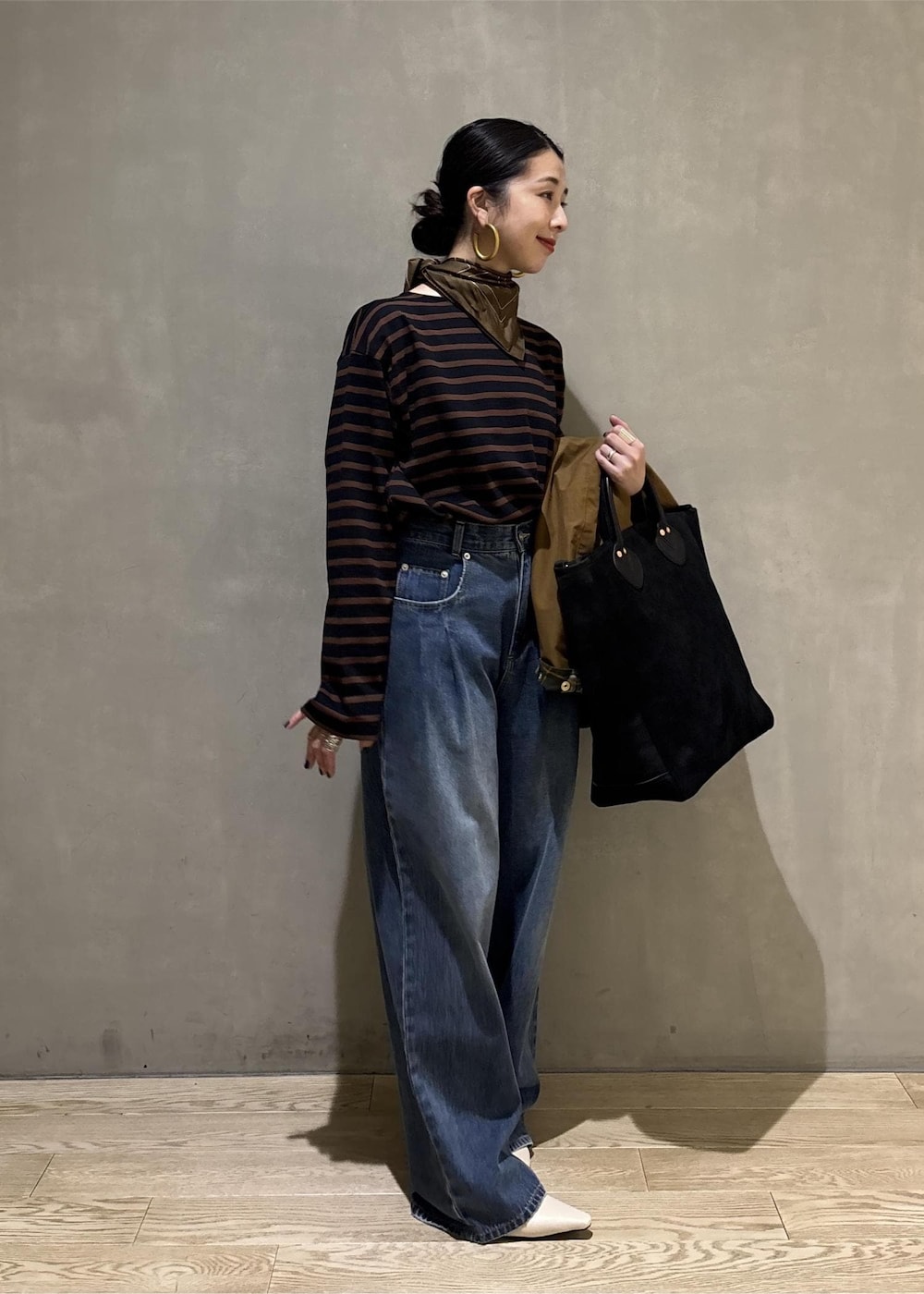 ブルー系のデニムパンツ、イエロー系のブルゾン、ブラウン系のTシャツ/カットソーを着用したレディースの夏コーディネートの3枚目の写真
