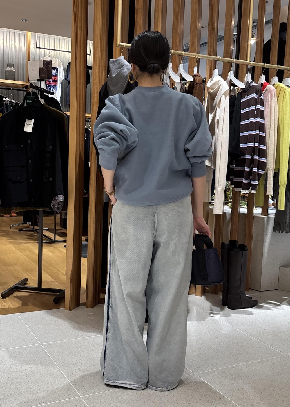 ブルー系のデニムパンツ、ブルー系のショルダーバッグ、ブルー系のスウェットを着用したレディースの秋コーディネートの5枚目の写真