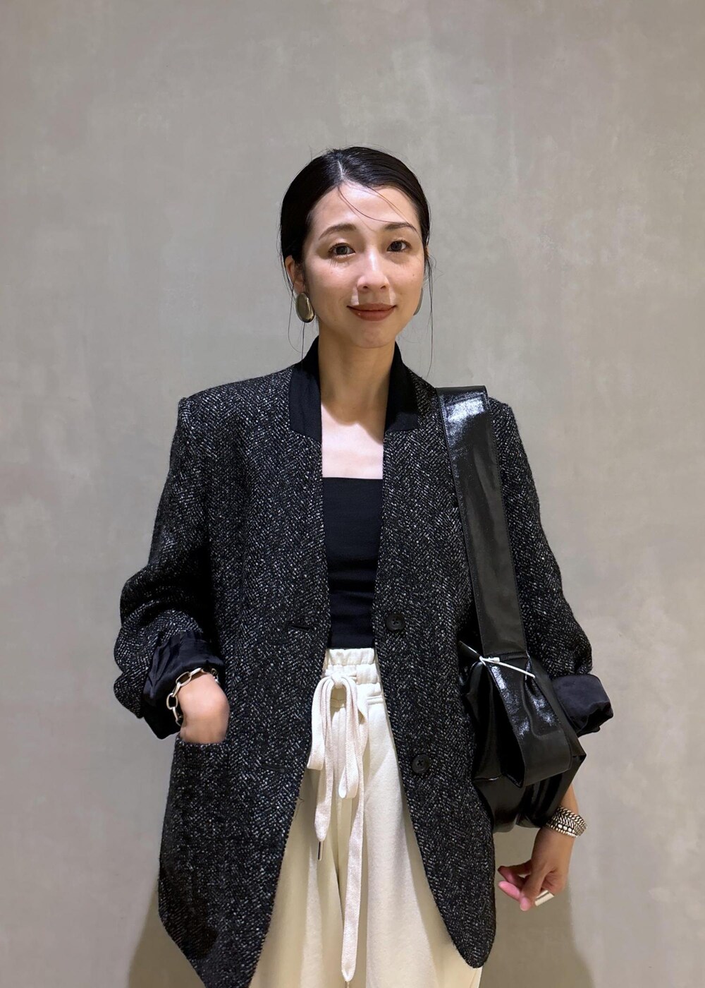 ホワイト系のスウェットパンツ、ブラック系のノーカラージャケット、ブラック系のショルダーバッグを着用したレディースの秋コーディネートの9枚目の写真