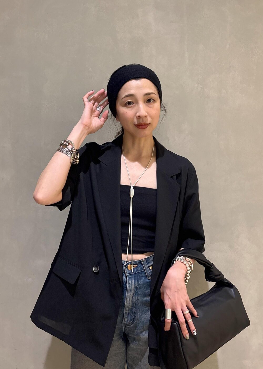 ブラック系のシャツ/ブラウス、ブルー系のデニムパンツ、シルバー系のネックレスを着用したレディースの夏コーディネートの7枚目の写真