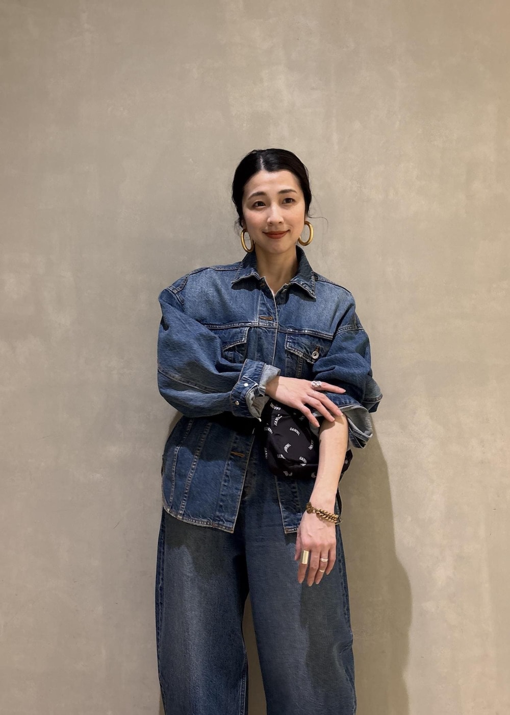 ブルー系のデニムジャケット、ブルー系のデニムパンツ、ブラック系のトートバッグを着用したレディースの春コーディネートの9枚目の写真