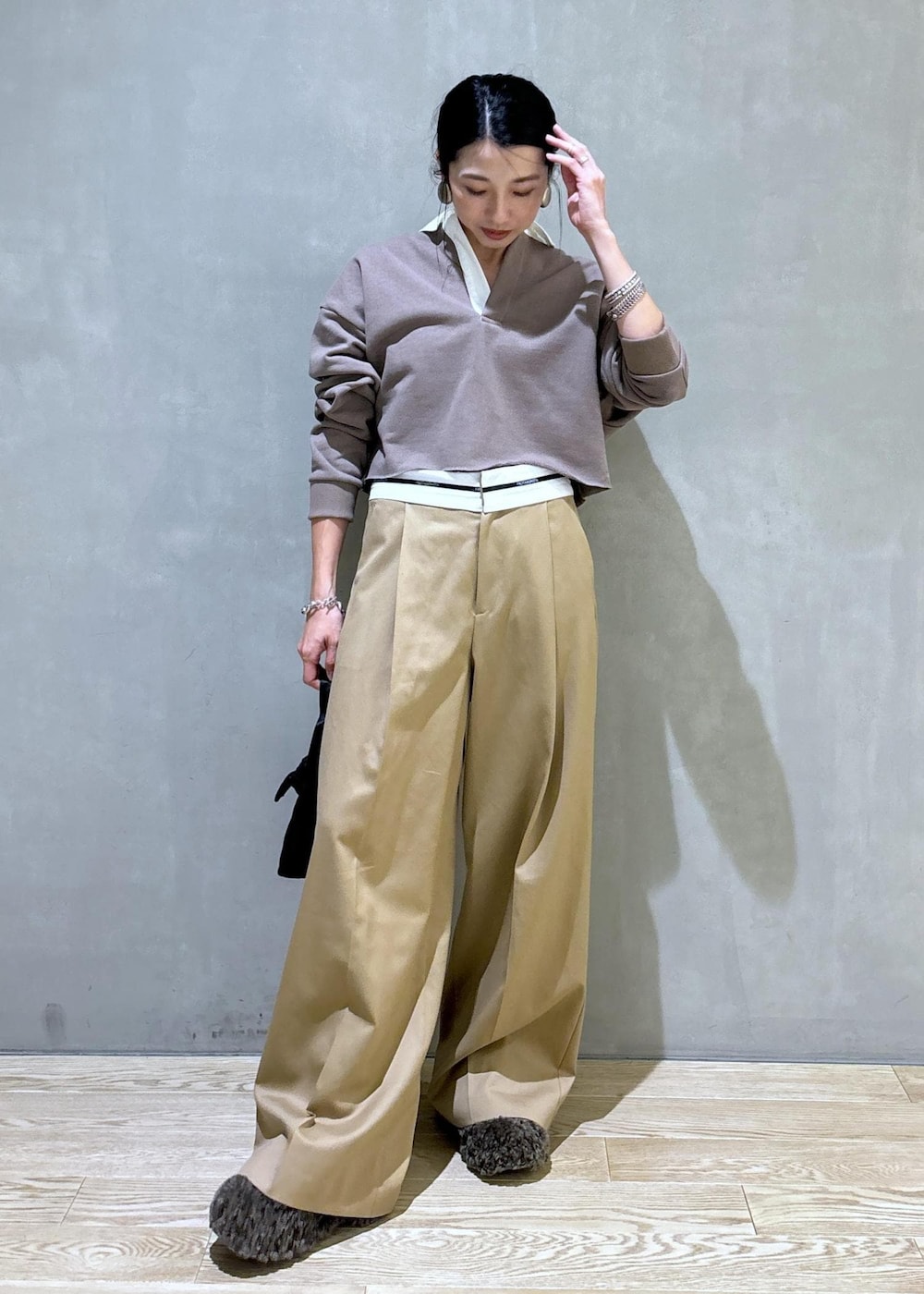 ブラック系のハンドバッグ、ブラウン系のサンダル、ベージュ系のTシャツ/カットソーを着用したレディースの秋コーディネートの2枚目の写真