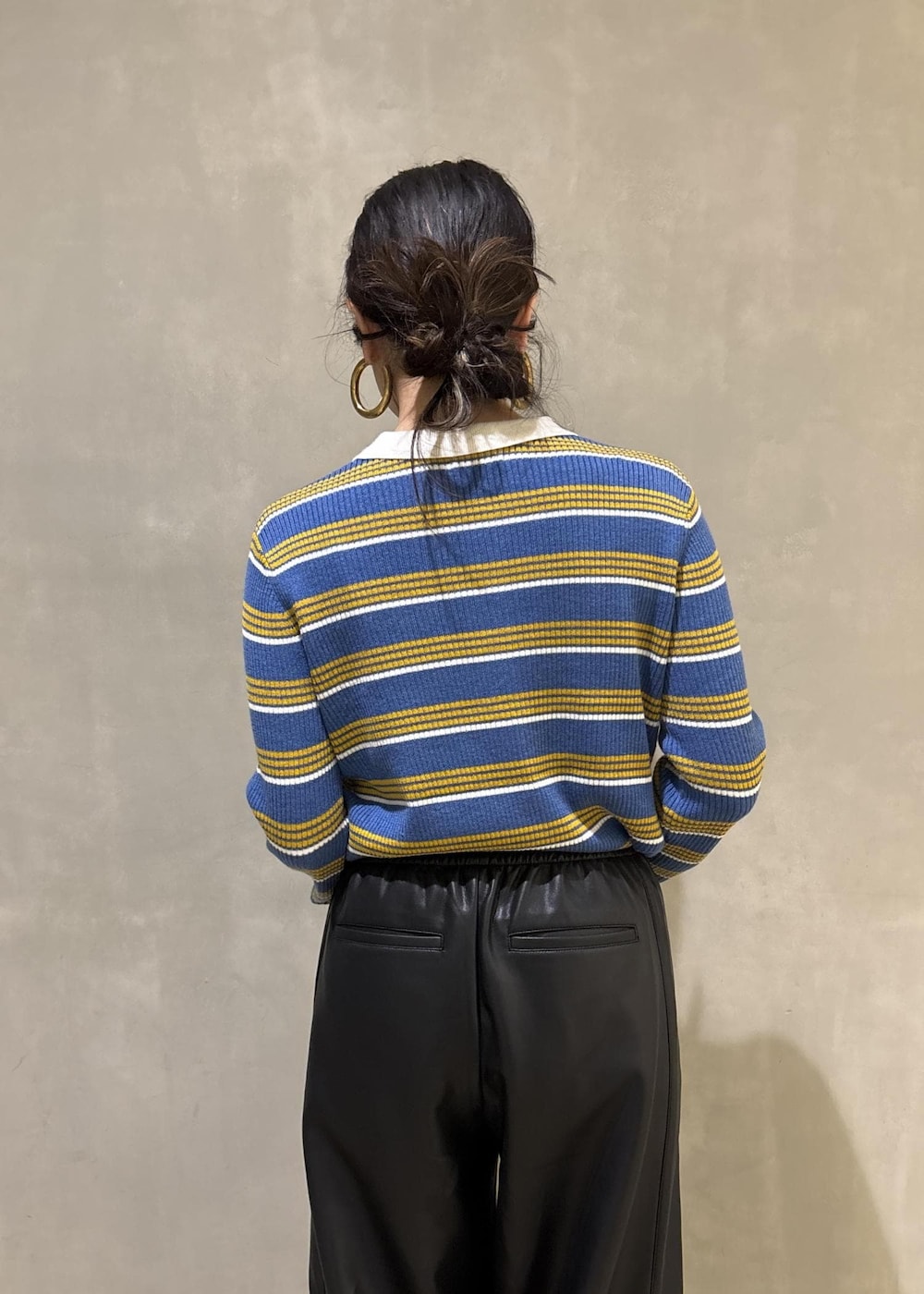 ブルー系のポロシャツ、ブラック系のその他パンツ、イエロー系のキーホルダーを着用したレディースの秋コーディネートの9枚目の写真