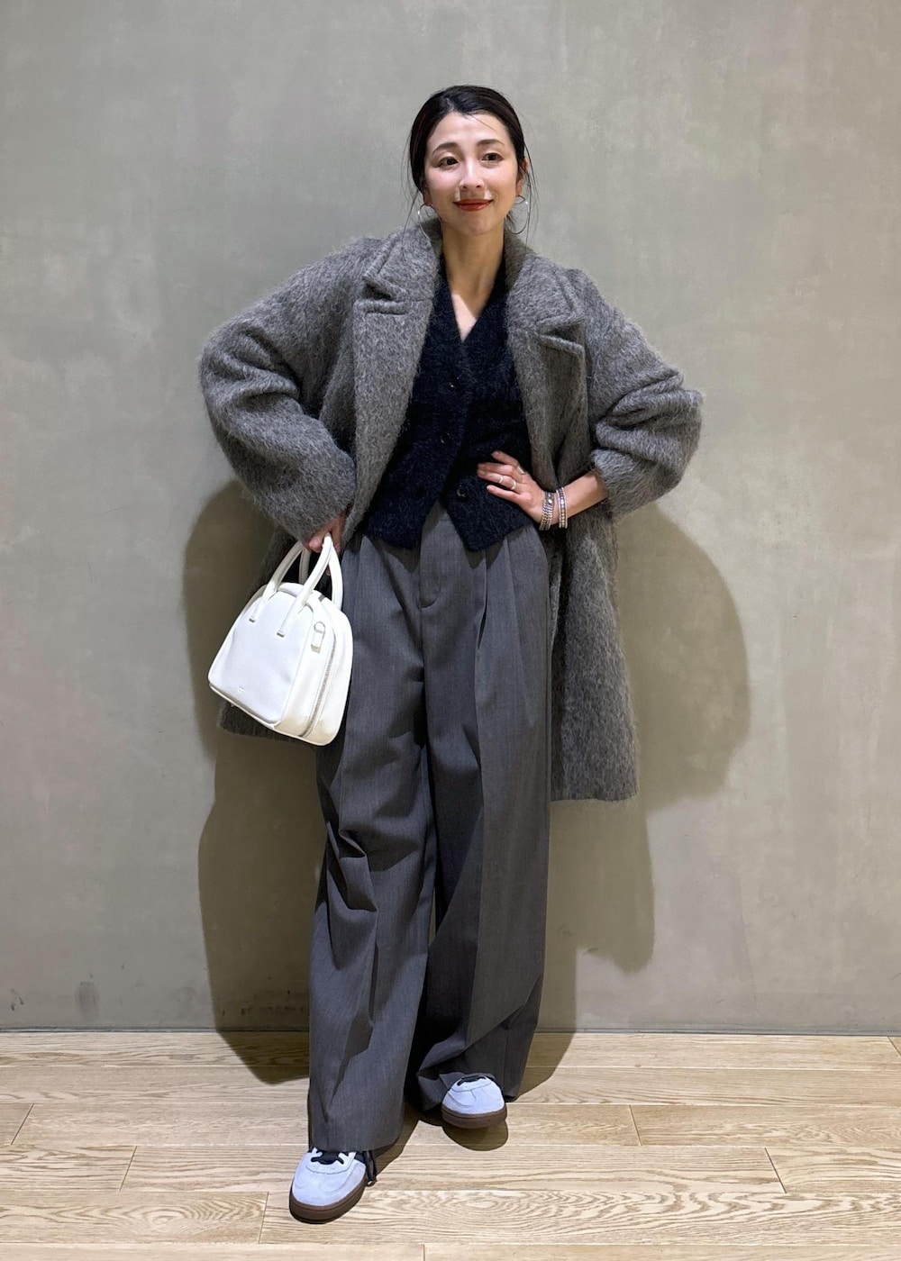 ホワイト系のボストンバッグ、グレー系のカーディガン/ボレロ、グレー系のチェスターコートを着用したレディースの秋コーディネートの2枚目の写真