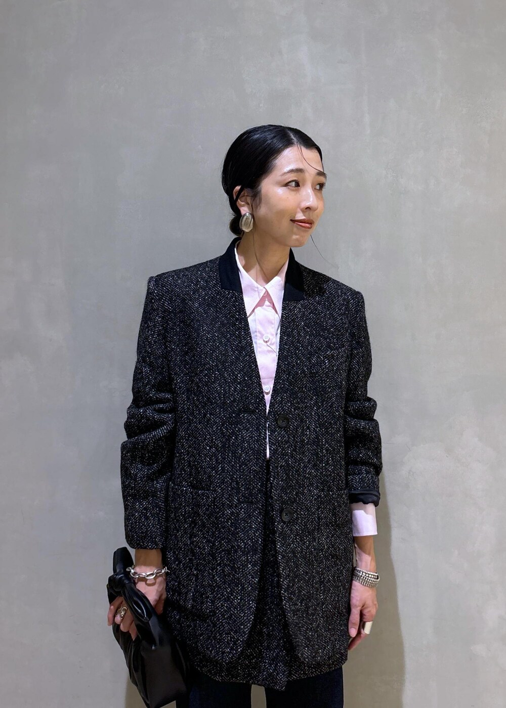 ブラック系のショルダーバッグ、ホワイト系のパンプス、ブルー系のデニムパンツを着用したレディースの夏コーディネートの10枚目の写真