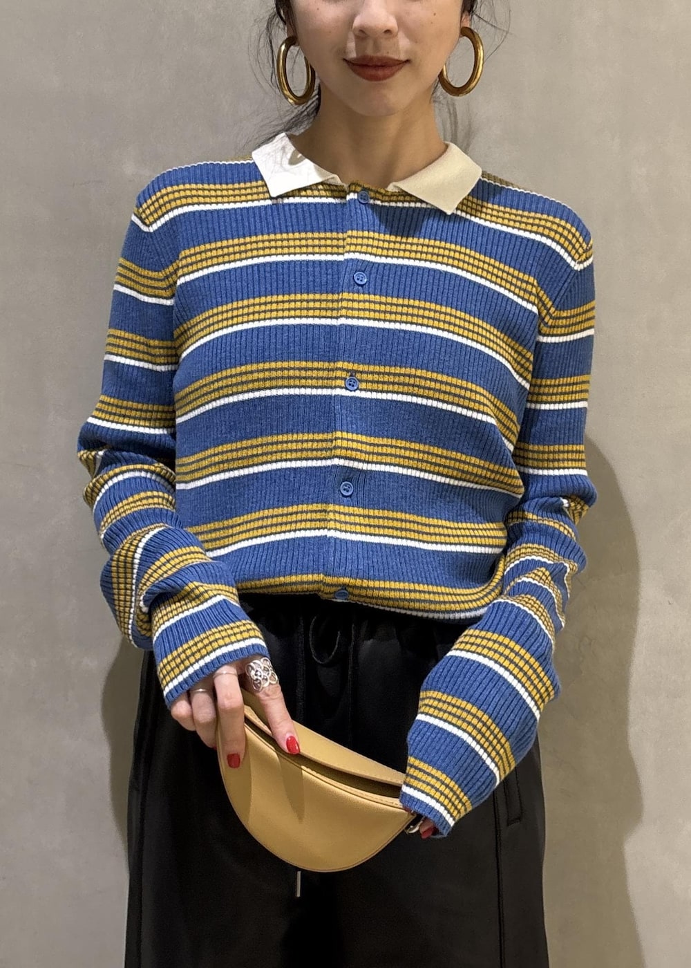 ブルー系のポロシャツ、ブラック系のその他パンツ、イエロー系のキーホルダーを着用したレディースの秋コーディネートの7枚目の写真