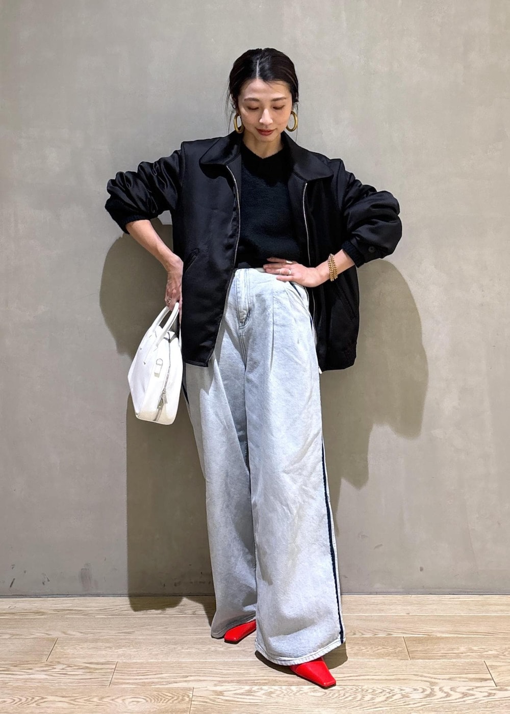 ブラック系のニット/セーター、ホワイト系のボストンバッグ、ブルー系のその他パンツを着用したレディースの冬コーディネートの3枚目の写真