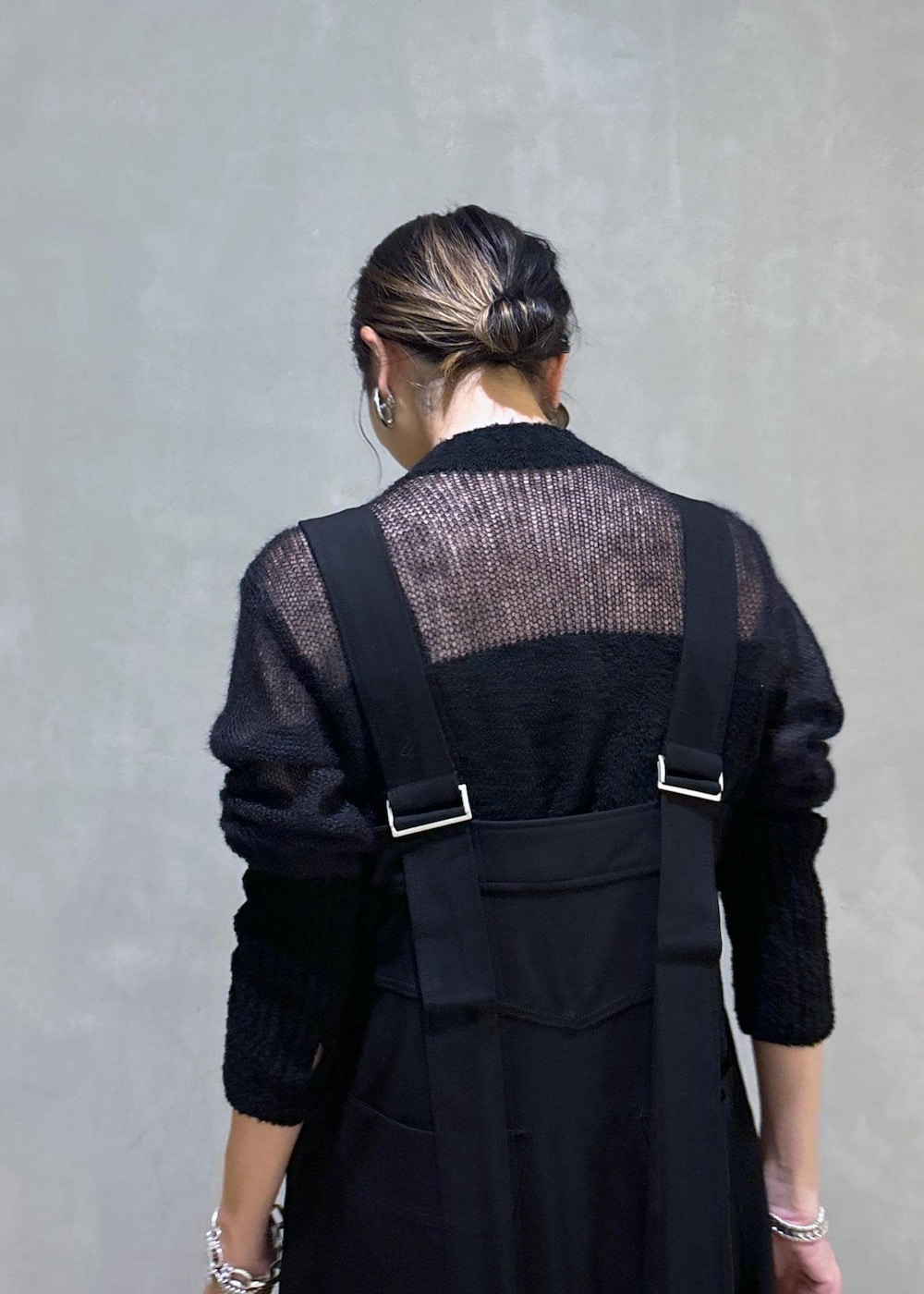 ホワイト系のボストンバッグ、ブラック系のワンピース、ブラック系のブーツを着用したレディースの秋コーディネートの9枚目の写真