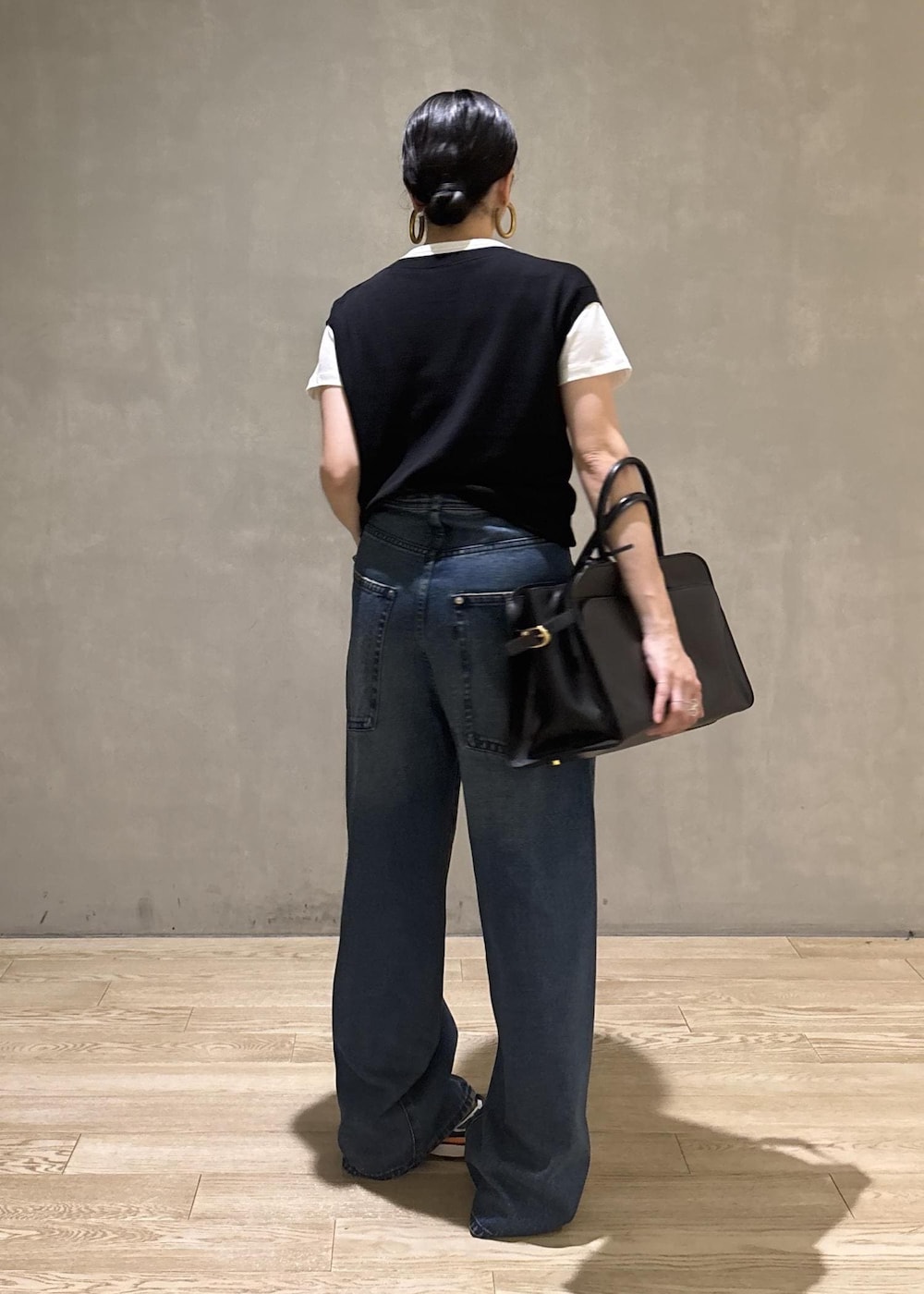 ブラック系のトートバッグ、ブラック系のTシャツ/カットソー、ブルー系のデニムパンツを着用したレディースの夏コーディネートの4枚目の写真