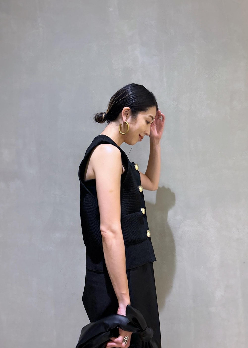 シルバー系のスニーカー、ブラック系のニット/セーター、ブラック系のショルダーバッグを着用したレディースの夏コーディネートの9枚目の写真