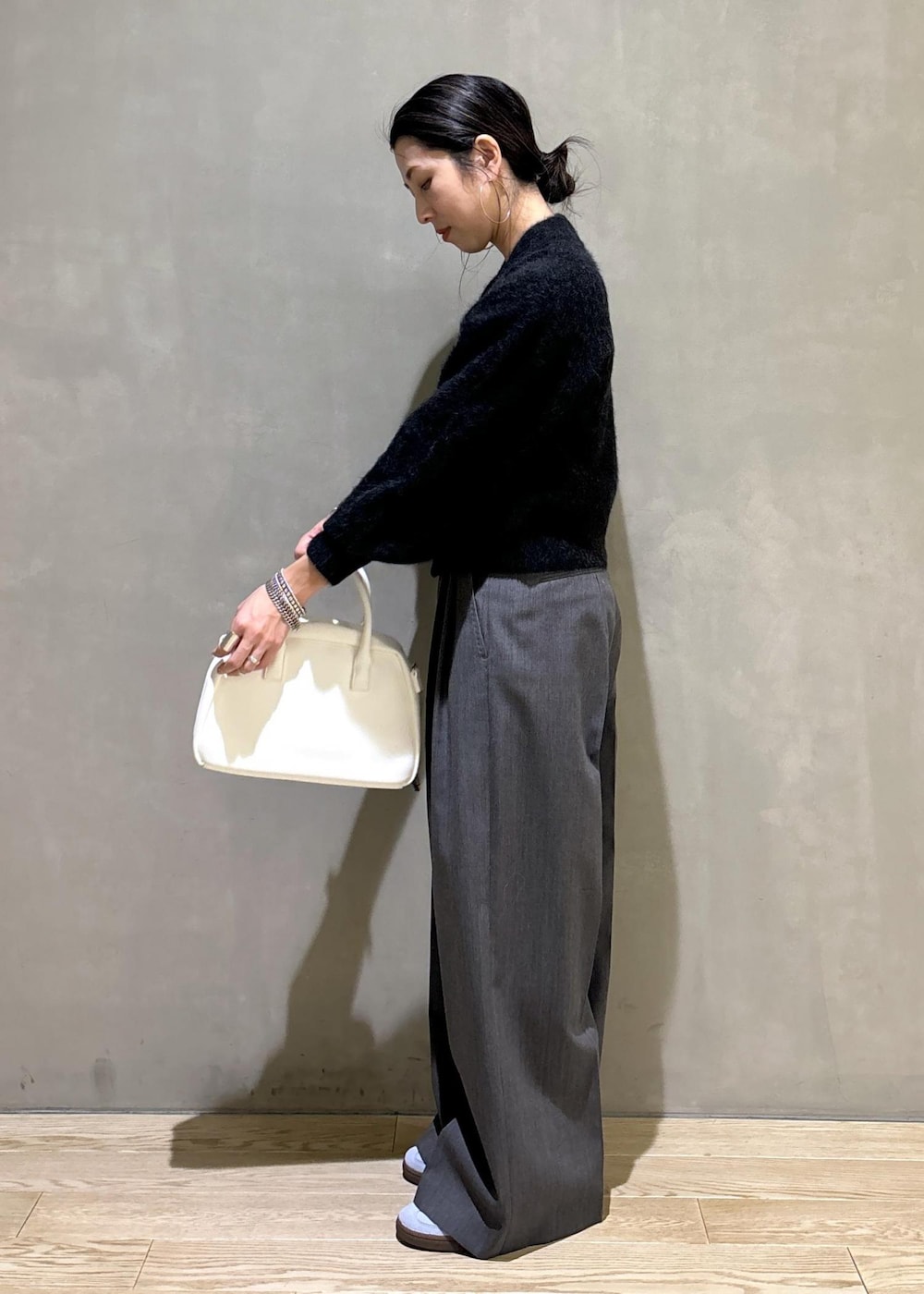 ホワイト系のボストンバッグ、グレー系のカーディガン/ボレロ、ブルー系のスニーカーを着用したレディースの秋コーディネートの7枚目の写真