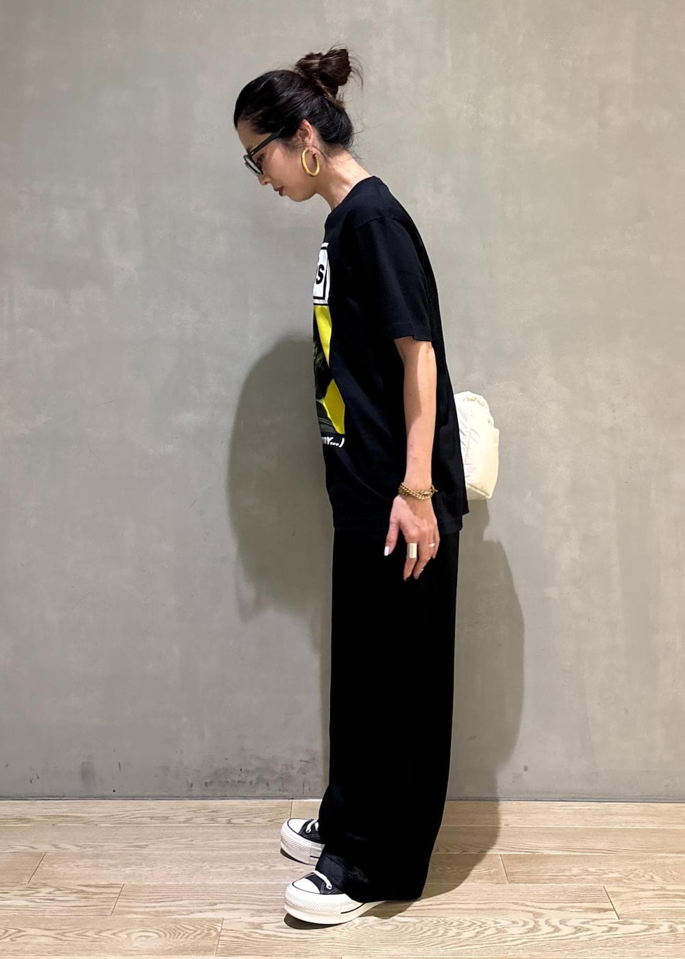 ブラック系のスラックス、イエロー系のTシャツ/カットソーを着用したレディースの夏コーディネートの4枚目の写真