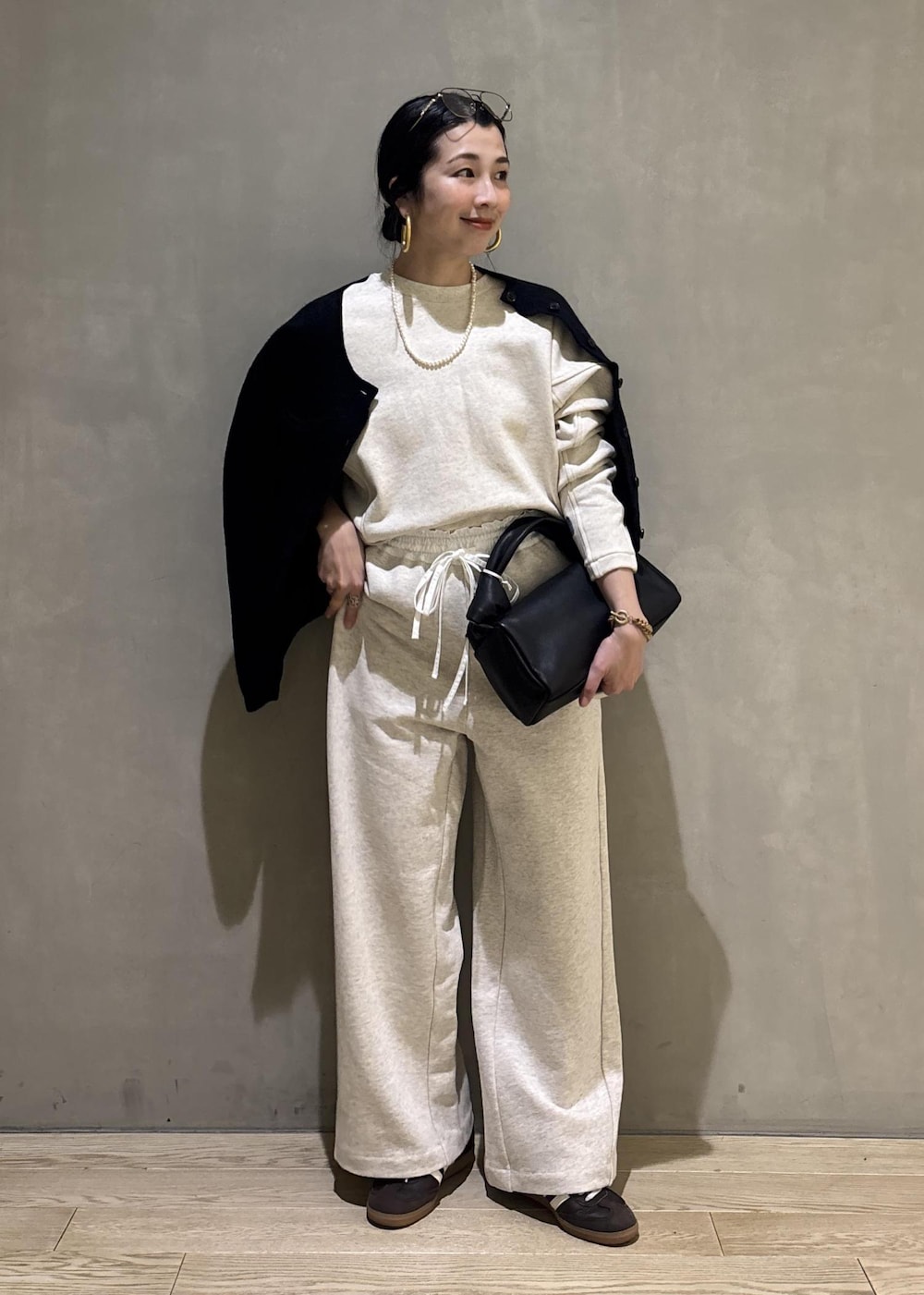 ブラック系のハンドバッグ、ホワイト系のその他パンツ、ホワイト系のスウェットを着用したレディースの冬コーディネートの7枚目の写真