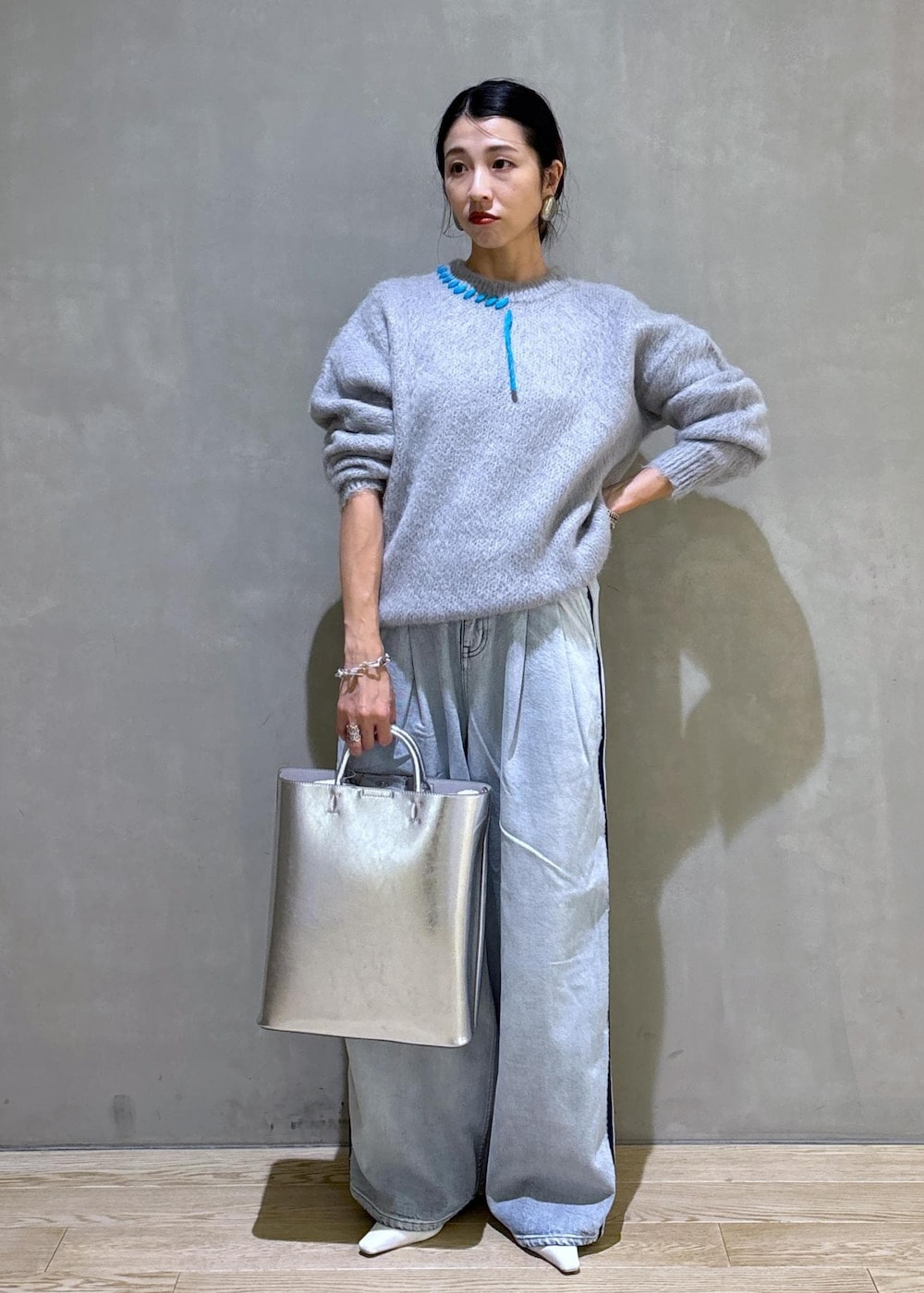 ホワイト系のパンプス、シルバー系のトートバッグ、ブルー系のその他パンツを着用したレディースの秋コーディネートの3枚目の写真