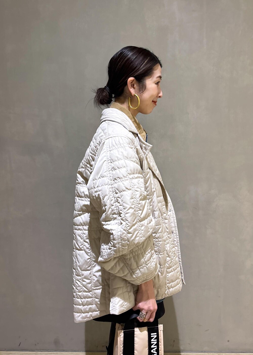 ベージュ系のトートバッグ、ブラック系のブーツ、ブラック系のスカートを着用したレディースの冬コーディネートの7枚目の写真