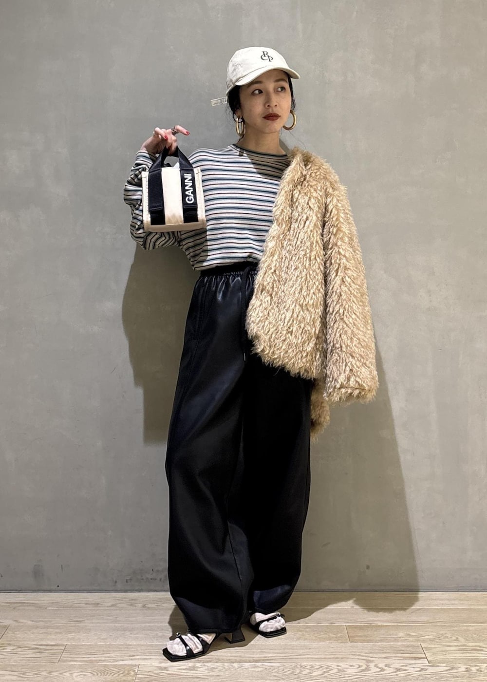 ベージュ系のトートバッグ、ベージュ系のその他アウター、ブラック系のその他パンツを着用したレディースの秋コーディネートの3枚目の写真