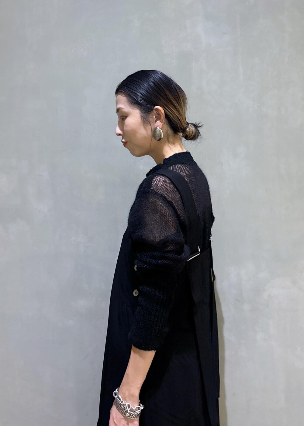 ホワイト系のボストンバッグ、ブラック系のワンピース、ブラック系のブーツを着用したレディースの秋コーディネートの10枚目の写真