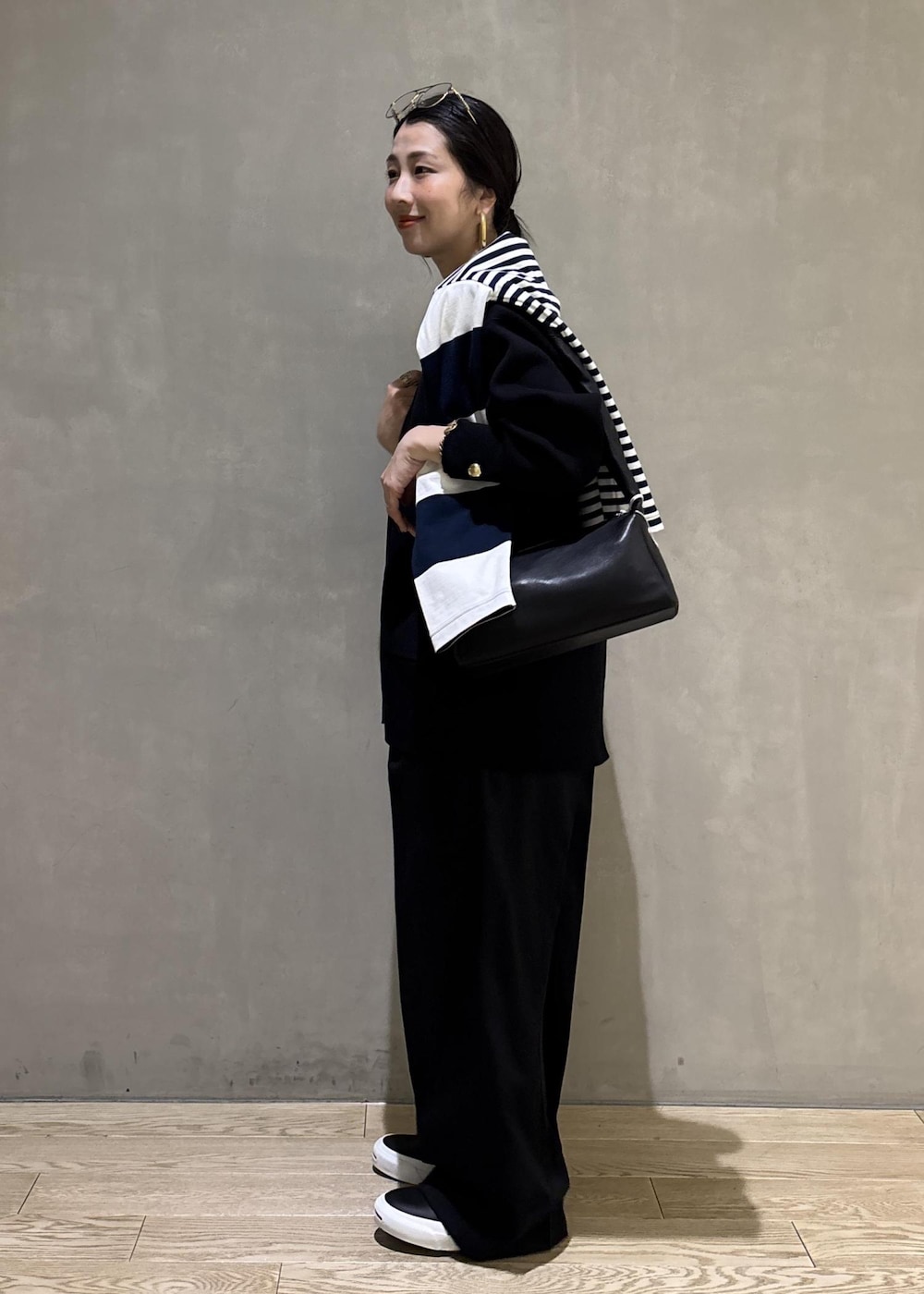 ブルー系のTシャツ/カットソー、ブラック系のカーディガン/ボレロ、ブラック系のスラックスを着用したレディースの冬コーディネートの10枚目の写真