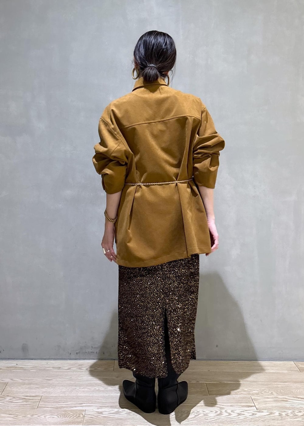 ブラック系のブーツ、ブラック系のスカート、イエロー系のブルゾンを着用したレディースの冬コーディネートの5枚目の写真