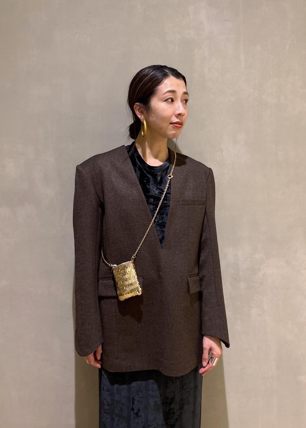 ブラック系のスカート、ブラック系のTシャツ/カットソー、ゴールド系のブーツを着用したレディースの冬コーディネートの9枚目の写真