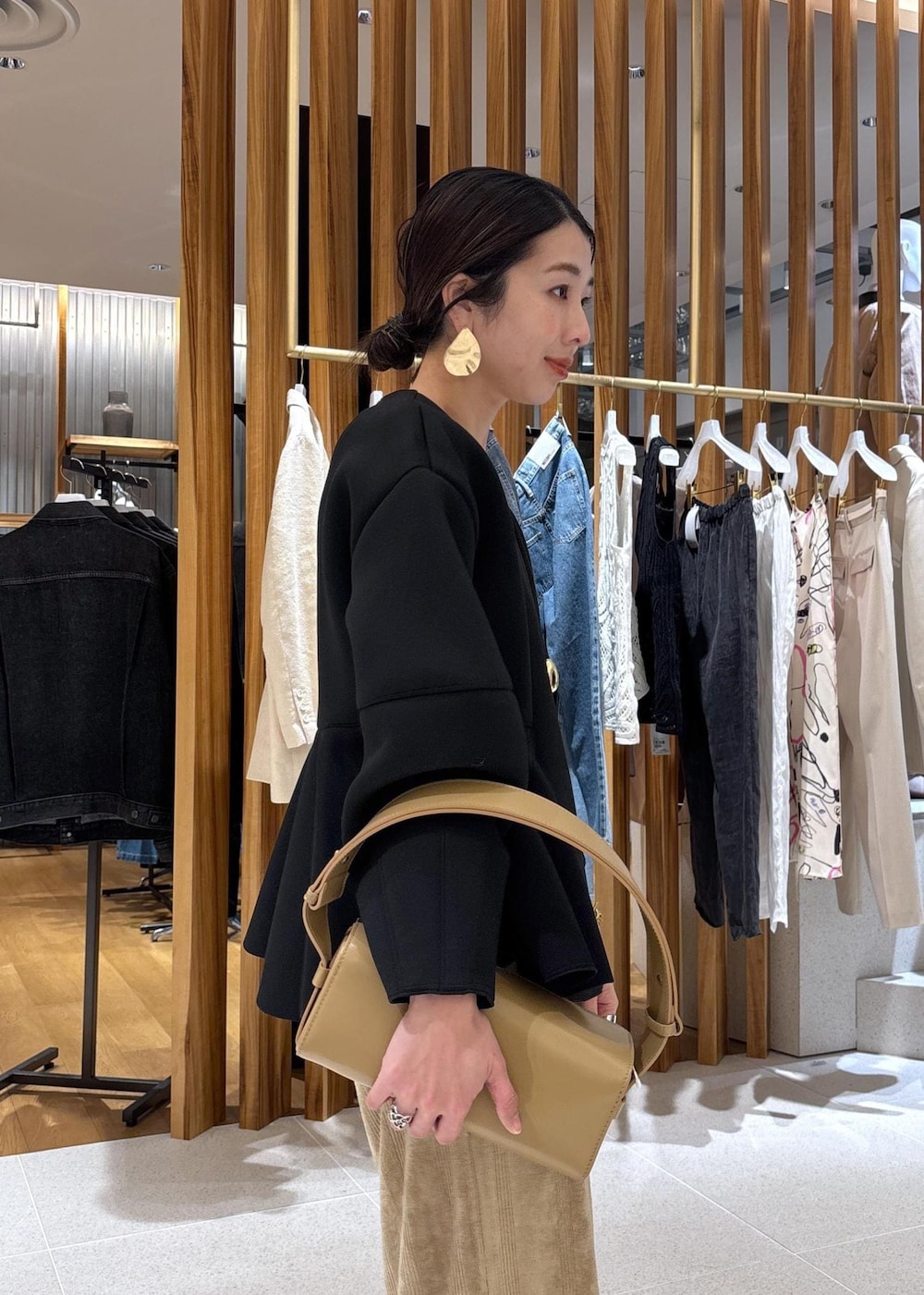 ベージュ系のハンドバッグ、ブラック系のローファー、ブラック系のカーディガン/ボレロを着用したレディースの冬コーディネートの10枚目の写真