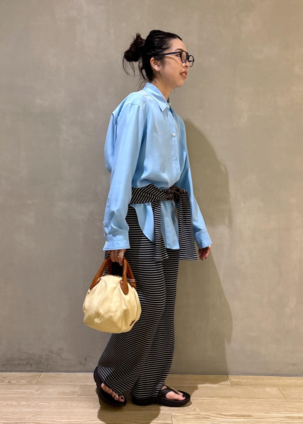 ブルー系のシャツ/ブラウス、ブラック系のサンダルを着用したレディースの夏コーディネートの3枚目の写真