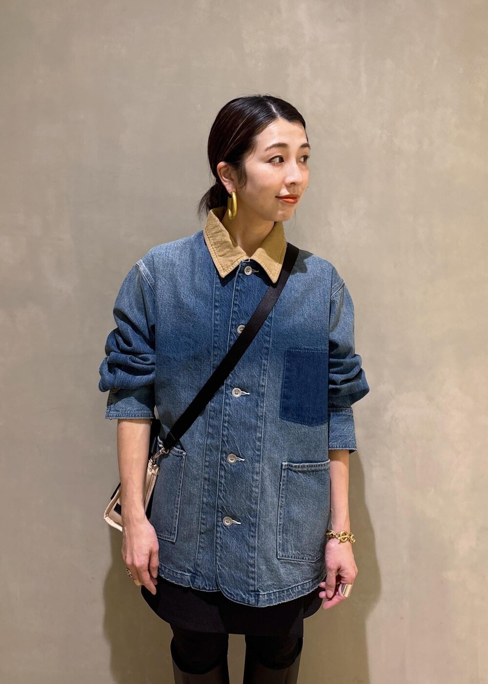 ベージュ系のトートバッグ、ブラック系のブーツ、ブラック系のスカートを着用したレディースの冬コーディネートの6枚目の写真