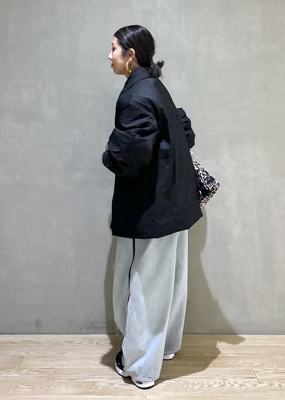 ベージュ系のトートバッグ、ブルー系のその他パンツ、ブラック系のブルゾンを着用したレディースの秋コーディネートの6枚目の写真