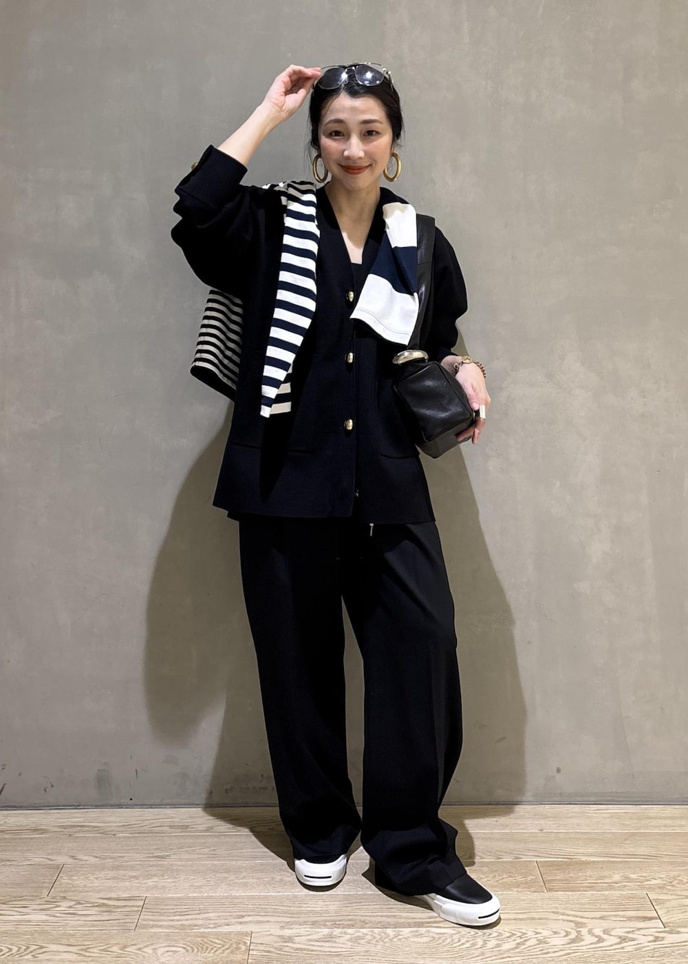 ブルー系のTシャツ/カットソー、ブラック系のカーディガン/ボレロ、ブラック系のスラックスを着用したレディースの冬コーディネートの3枚目の写真